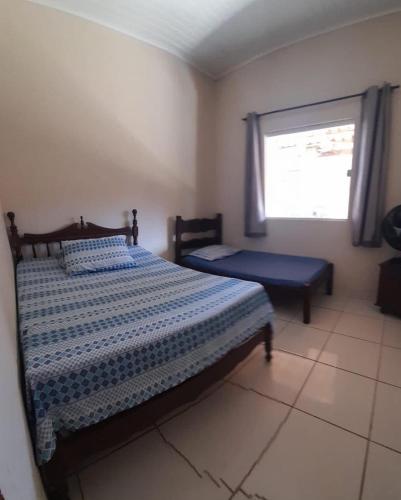 a bedroom with a bed and a window at Casa de férias Amarela em Prado in Prado