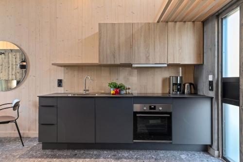a kitchen with black cabinets and a sink at Topcamp Bogstad - Oslo in Oslo