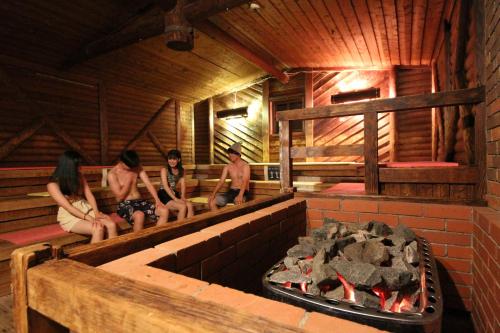 a group of people sitting in a sauna with a fireplace at Chateraise Gateaux Kingdom Sapporo Hotel & Spa Resort in Sapporo