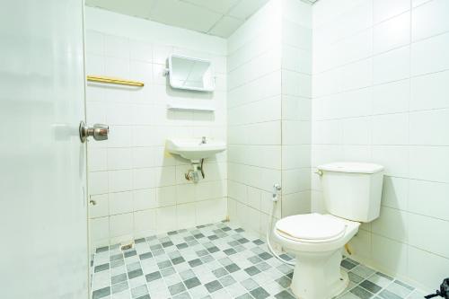 a bathroom with a toilet and a sink at Boonchai Mansion in Hat Yai