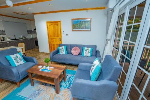 a living room with two blue couches and a table at Paradise Breeze Apartment in Mahe
