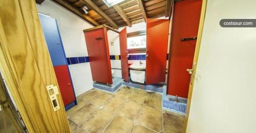 baño con paredes rojas y azules y aseo en La Majada en Ciudad-Rodrigo
