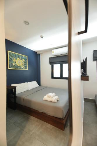 a bedroom with a bed with a blue wall at WiRE BANGKOK PRAKHANONG in Amphoe Phra Khanong