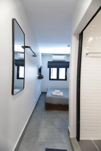 a small bedroom with a bed and a mirror at WiRE BANGKOK PRAKHANONG in Amphoe Phra Khanong