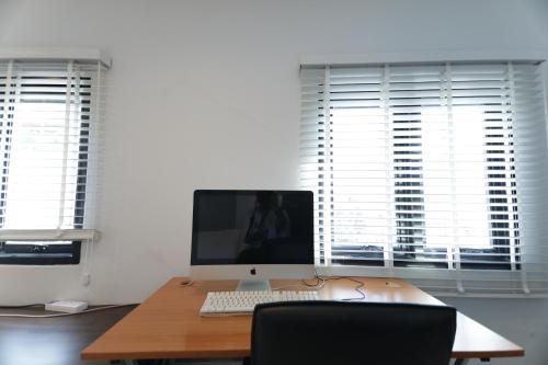 a desk with a computer monitor and a keyboard at WiRE BANGKOK PRAKHANONG in Amphoe Phra Khanong