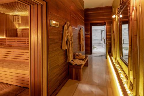 a sauna with wooden walls and a walk in shower at Hotel Çelik Palas Convention Center & Thermal SPA in Bursa