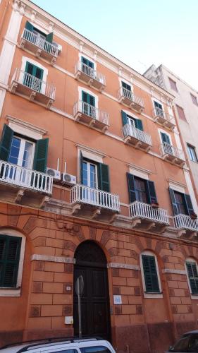 an orange brick building with balconies and a door at Affittacamere Museo in Taranto