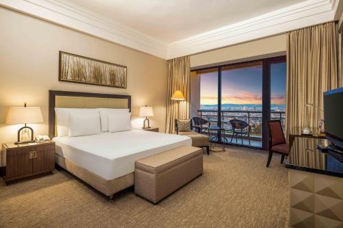 Hotel Çelik Palas Convention Center & Thermal SPA في بورصة: غرفه فندقيه بسرير وشرفه