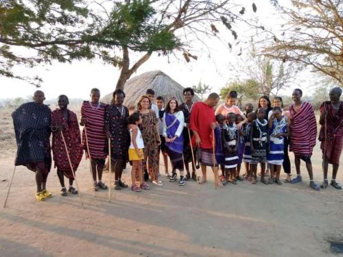 a group of people posing for a picture in front of a tree at Camp Bastian Mikumi in Mikumi