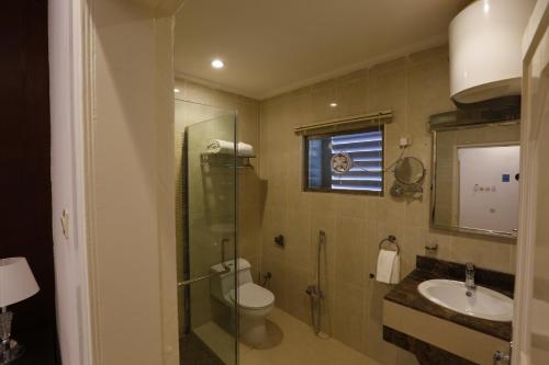 a bathroom with a toilet and a sink and a shower at فندق حصن الأبلق - Alablaq Hotel in Taymāʼ