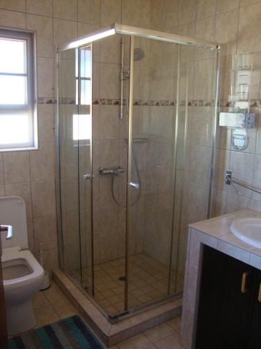 a shower with a glass door in a bathroom at Okambishi's Rest in Usakos