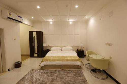 فندق حصن الأبلق - Alablaq Hotel في تيماء: غرفة نوم بسرير ومغسلة وكرسي
