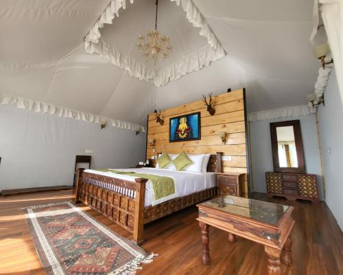a bedroom with a bed and a table at Nature Waterfall Resort, Bir in Chauntrā