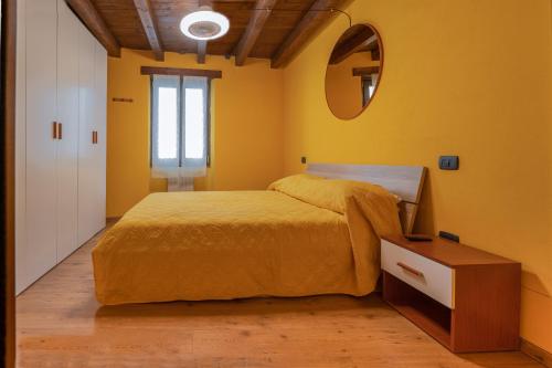 een gele slaapkamer met een bed en een spiegel bij Stylish 2 bedroom with balcony in Verona