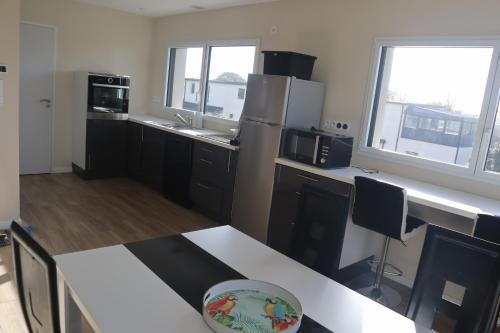 a kitchen with black cabinets and stainless steel appliances at Ty Enez Mor in Lanildut