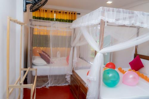a childs bedroom with a canopy bed and balloons at Rainforest Holiday Inn in Deniyaya