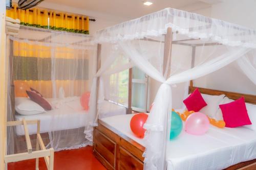 Rainforest Holiday Inn في دينيايا: غرفة نوم بسريرين بطابقين ونافذة