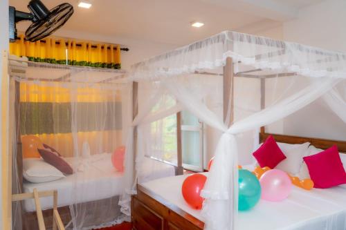 a bedroom with two bunk beds with balloons and a window at Rainforest Holiday Inn in Deniyaya