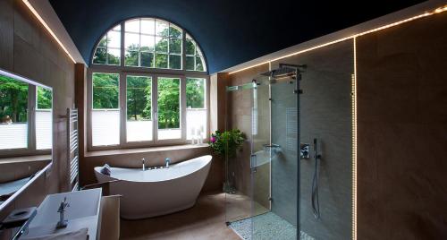 a bathroom with a large tub and a shower at Parkresidenz Lychen, Ferienwohnung 3 in Lychen