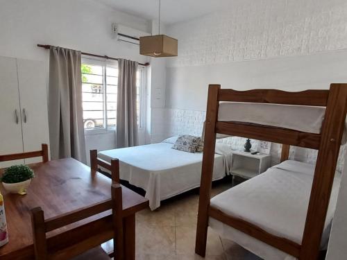 sypialnia z 2 łóżkami piętrowymi i stołem w obiekcie Hotel Are Pora w mieście Gualeguaychú