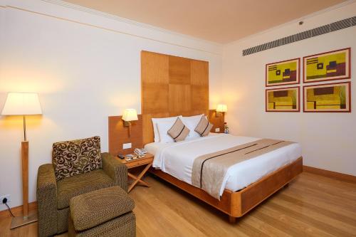 una camera d'albergo con letto e sedia di Park Plaza Chennai OMR a Chennai