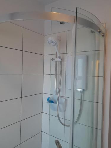 La salle de bains est pourvue d'une douche avec une porte en verre. dans l'établissement Marina Cottage, Newark, à Newark-on-Trent