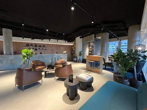 a large room with chairs and tables and plants at STAY Nordhavn in Copenhagen