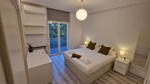 una camera con un letto bianco e una finestra di Espectacular apartamento en Cuzco / Alberto Alcocer a Madrid