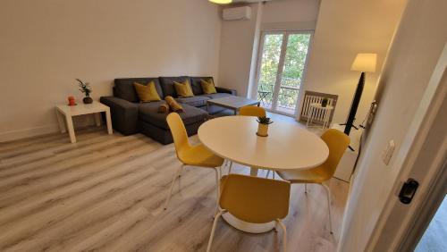 un soggiorno con tavolo e divano di Espectacular apartamento en Cuzco / Alberto Alcocer a Madrid