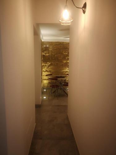 a hallway with a table and a light on a wall at La Perla della Cattedrale luxury home in Agrigento