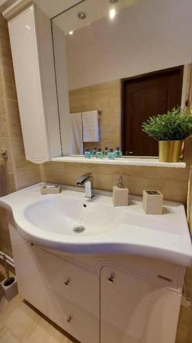 a bathroom with a white sink and a mirror at Ambiennt in Bucharest