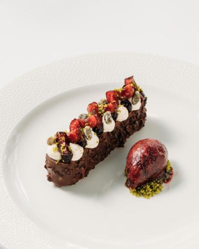 a piece of chocolate dessert with fruit on a white plate at Talland Bay Hotel, Looe in Talland