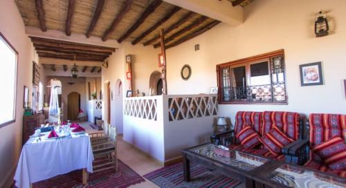 een woonkamer met een bank en een tafel bij Dune House in Merzouga