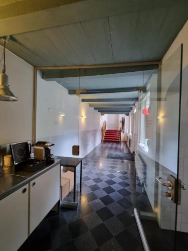 a kitchen with a checkered floor and a hallway at Het Waterhof in Leiden