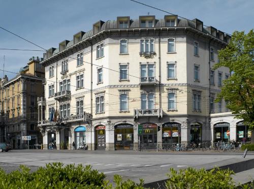 un grand bâtiment blanc au coin d'une rue dans l'établissement Hotel Grand'Italia, à Padoue