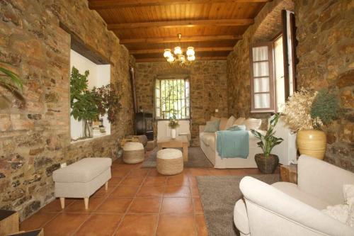 sala de estar con pared de piedra en Casa Rural Casa Selmo, en Carreno