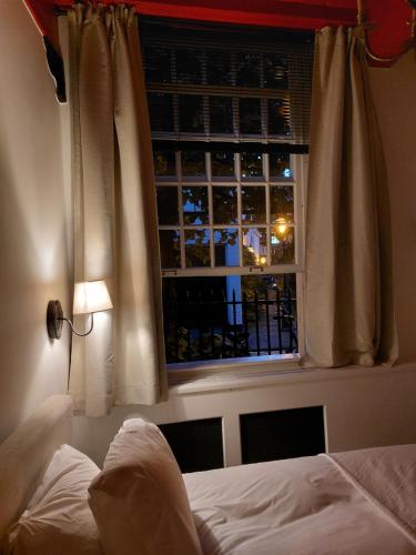 a bedroom with a bed and a window with a view at Het Waterhof in Leiden