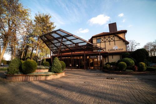 a building with awning in the middle of a courtyard at Sribni Leleky Hotel & Spa in Lutsk