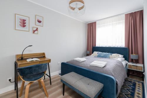 a bedroom with a blue bed and a desk at Nad Potokiem Apartment Poznań by Renters in Poznań