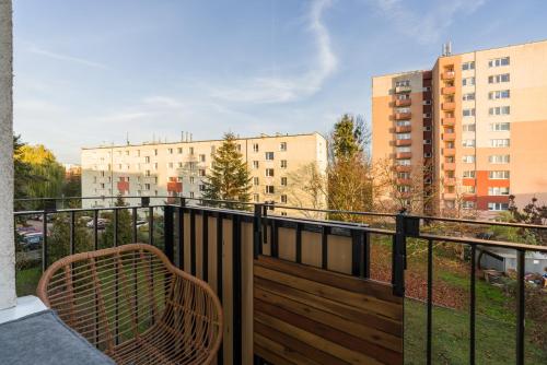 a balcony with a bench and a view of buildings at Nad Potokiem Apartment Poznań by Renters in Poznań