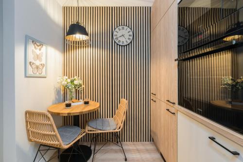 Habitación con mesa, sillas y reloj en la pared en Nad Potokiem Apartment Poznań by Renters en Poznan