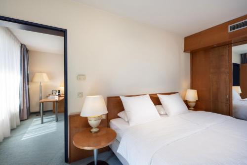 a hotel room with a bed and a mirror at Maritim Hotel Frankfurt in Frankfurt/Main