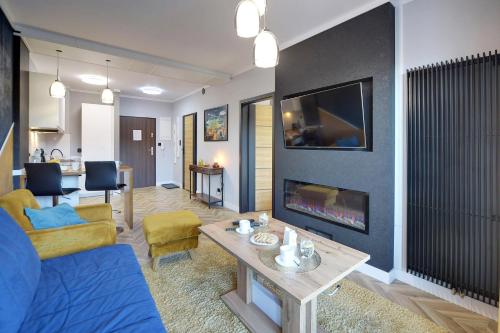 un soggiorno con divano e camino di Apartamenty Sun Seasons 24 - Karpatia a Karpacz
