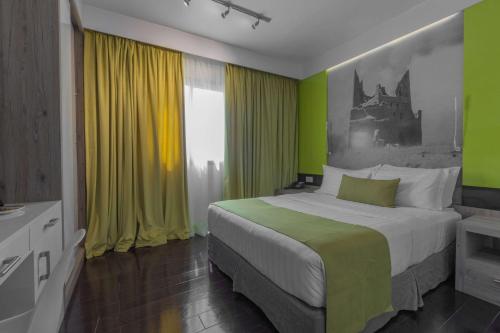 a bedroom with a bed with green and yellow walls at Super 8 Hotel Al Riyadh by Wyndham in Riyadh