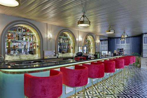 a bar with red chairs in a room at Swaroop Vilas - Lake Facing Boutique Hotel in Udaipur