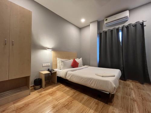 um pequeno quarto com uma cama e uma televisão em Hotel Zen Garden em Guwahati