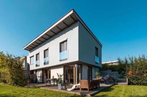 uma grande casa branca com bancos num quintal em Cozy terraced house with infra sauna and parking em Jesenice