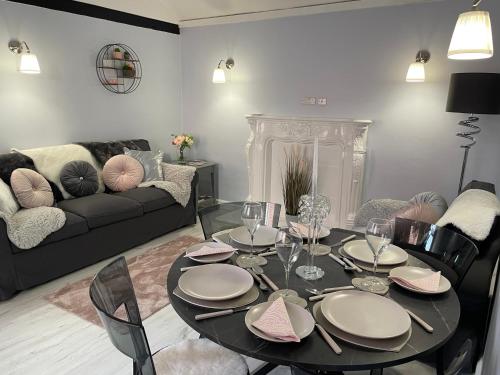 ein Wohnzimmer mit einem Tisch und einem Sofa in der Unterkunft Courtyard Holiday Apartments in Belper