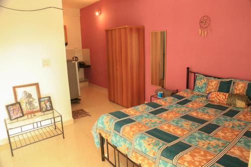 a bedroom with a large bed and a red wall at Dreamcatcher House & Hostel at Arambol Beach in Arambol