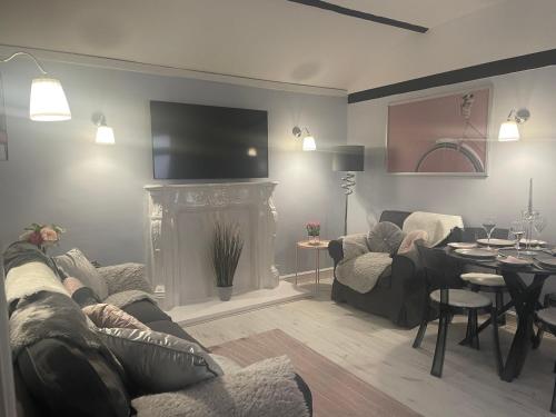 - un salon avec un canapé et une cheminée dans l'établissement Courtyard Holiday Apartments, à Belper